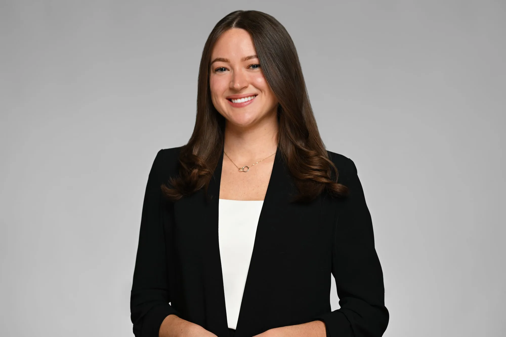 ERAS-ready medical residency headshot: black blazer over a white top, grey background