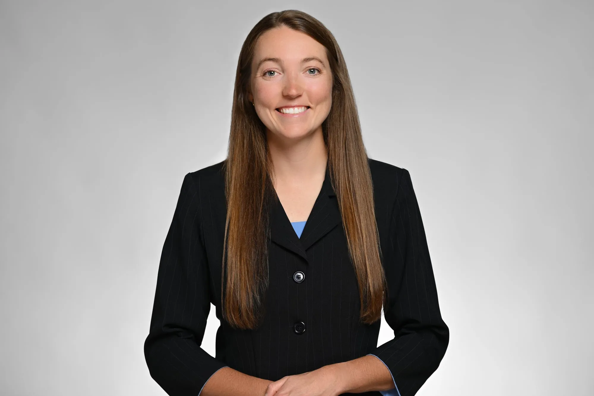 ERAS-ready medical residency headshot: black suit and long hair, grey background