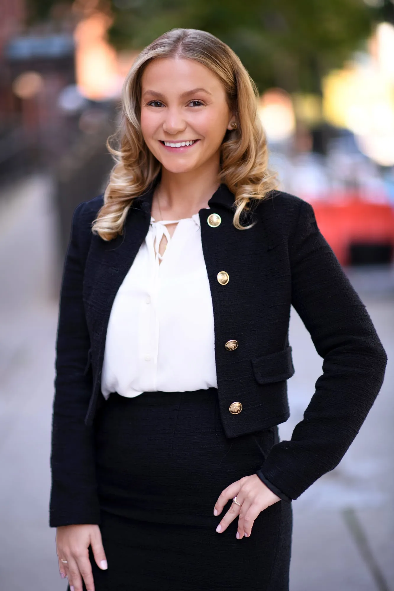 On-location headshot in Denver: black jacket and skirt on a city sidewalk