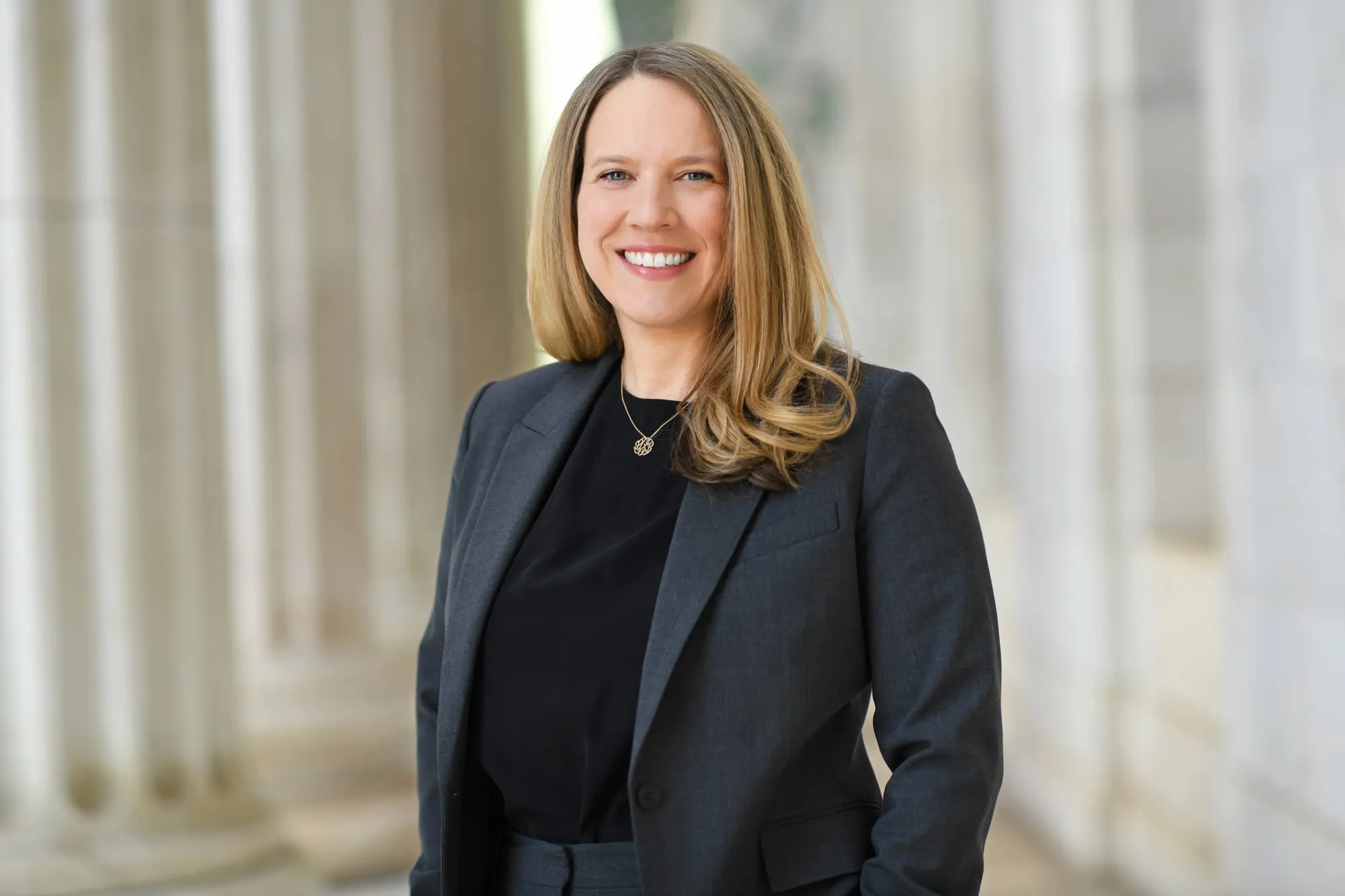 On-location headshot in Denver: black blazer beside stone columns