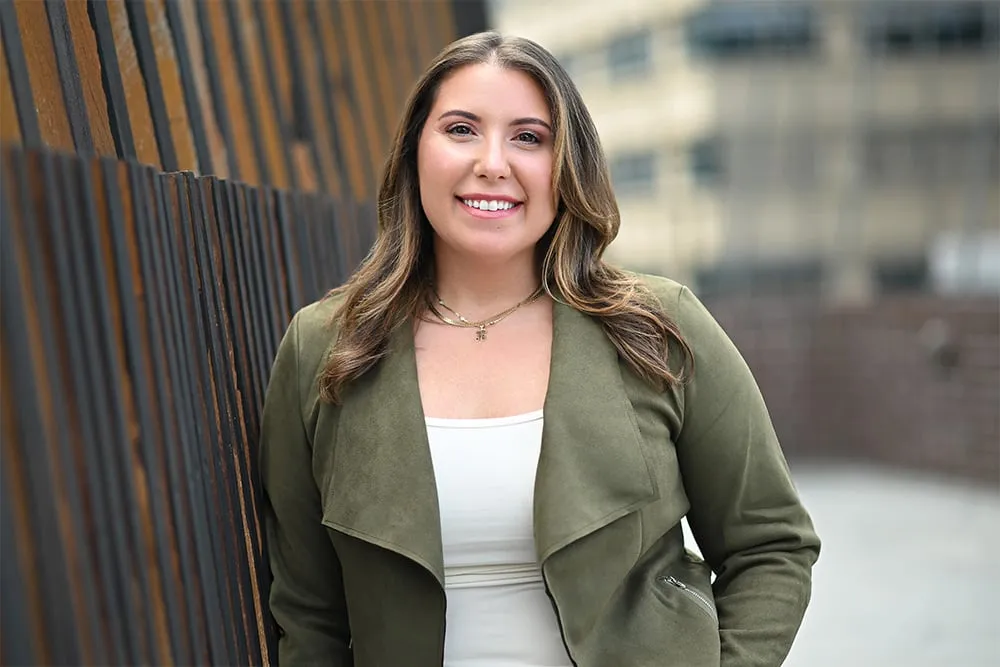 On-location headshot in Denver: olive jacket beside a wood-slat wall