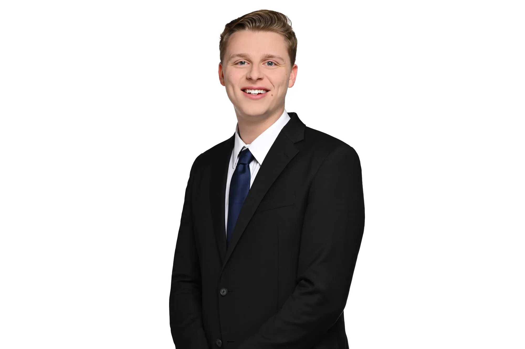 Studio headshot on a white background: black suit and navy tie