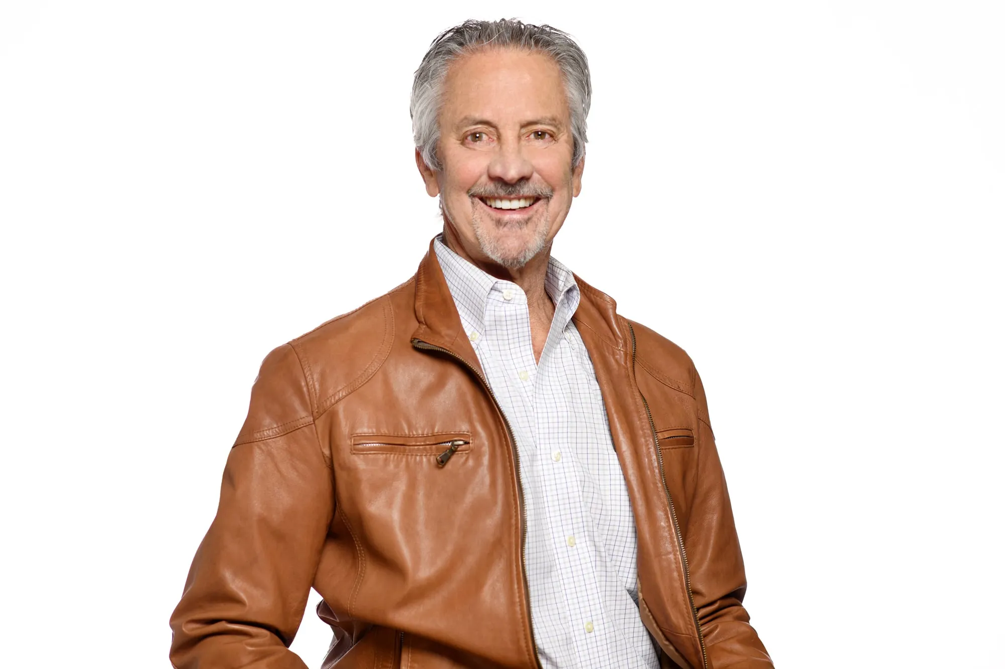 Studio headshot on a white background: cognac leather jacket and white shirt