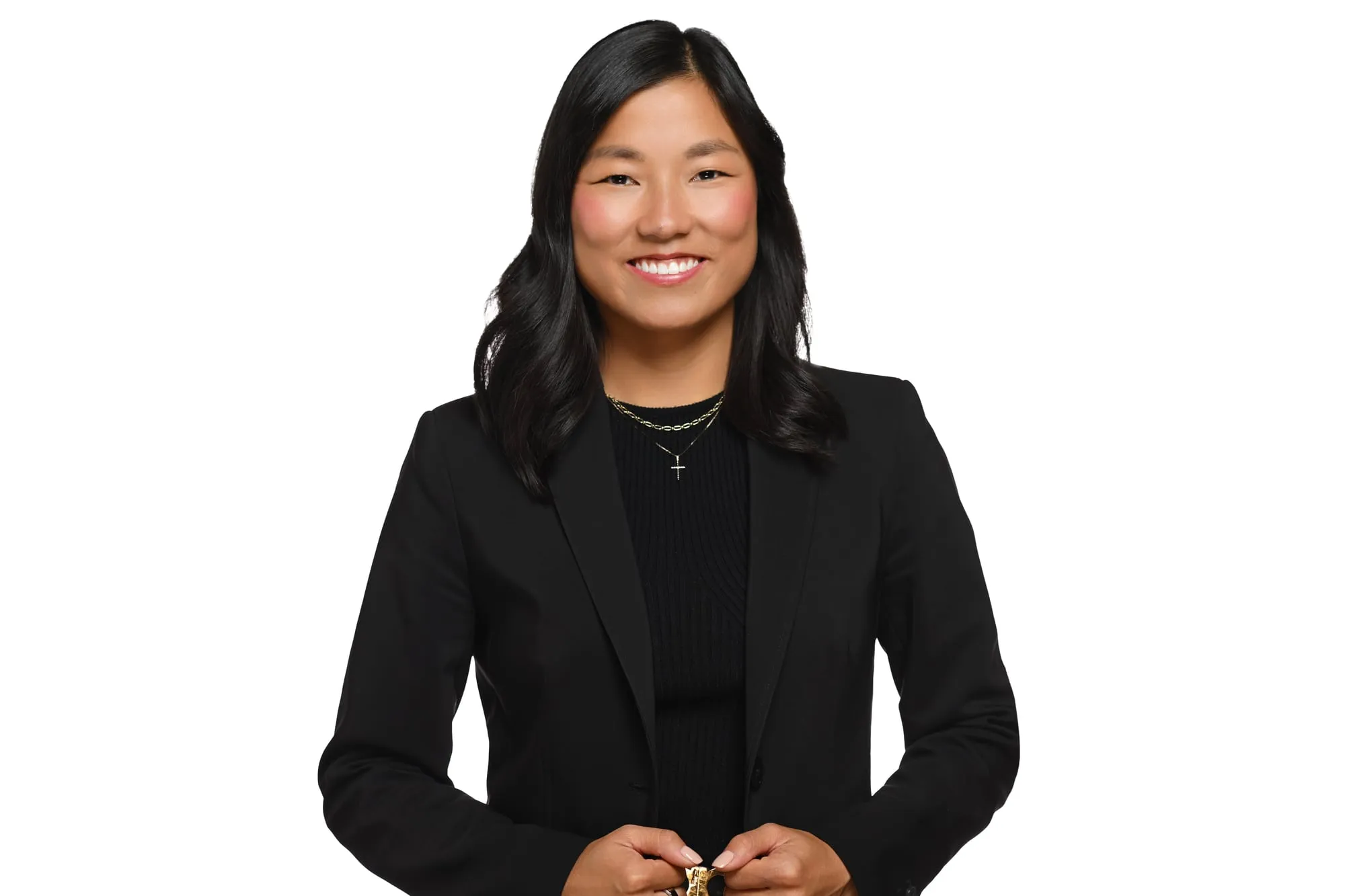Studio headshot on a white background: black blazer and a warm smile