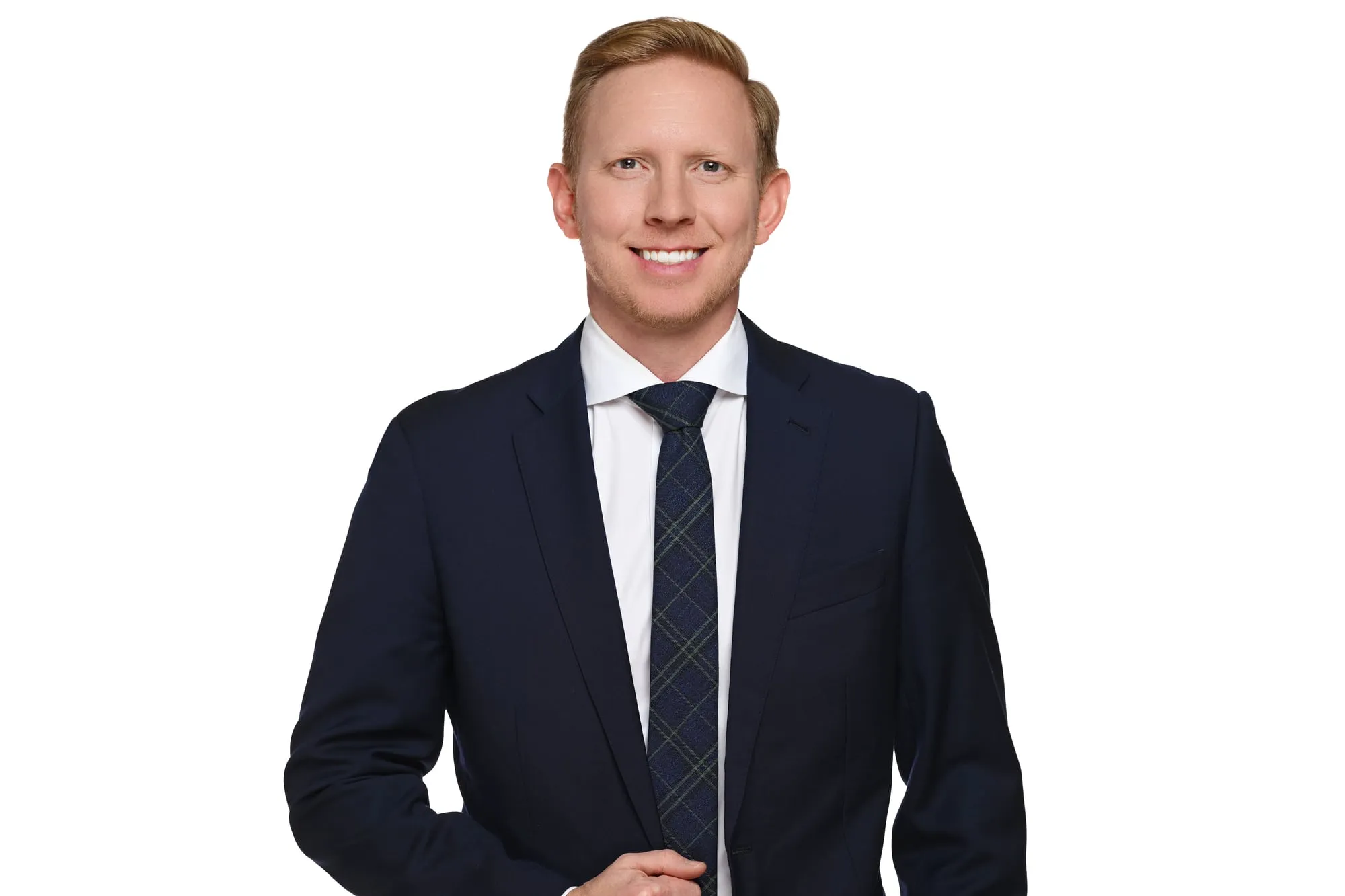 Studio headshot on a white background: navy suit and dark tie