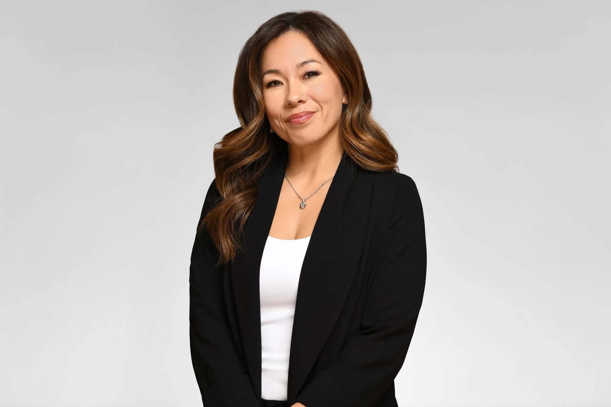Corporate headshot for Tract in Denver on a light grey background: black blazer over a white top